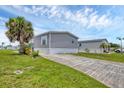 The home features well-maintained lawns, a concrete driveway, and tropical landscaping at 7337 Desant Ln, Port Charlotte, FL 33981