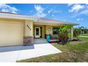 Welcoming front porch with stone accents, seating, and tropical landscaping at 9325 Crugar Ter, Englewood, FL 34224