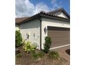 Well-maintained exterior view of home, featuring a two-car garage and neat landscaping at 10258 Morning Mist Ln, Sarasota, FL 34241