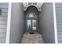 Inviting covered entryway with a beautiful blue double door at 10487 Coquina Ct, Placida, FL 33946