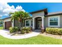 Charming home exterior with landscaped front yard and stone column accents at entrance at 1119 Boundary Blvd, Rotonda West, FL 33947