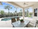 Enclosed patio area featuring a pool, table, and chairs perfect for entertaining or relaxation at 117 Abercrombie Ave, Englewood, FL 34223