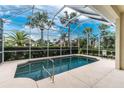 Screened-in pool area is surrounded by lush landscaping and offering privacy and relaxation at 117 Abercrombie Ave, Englewood, FL 34223