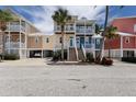 Inviting multi-story home with colorful exterior and a spacious front porch with white railings at 11780 Anglers Club Dr # 107, Placida, FL 33946
