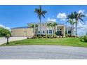 Two-story home with a metal roof, three-car garage, palms, and lush landscaping at 12438 Prather Ave, Port Charlotte, FL 33981