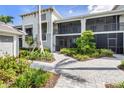Exterior building view featuring brick pathway and tropical landscaping at 12550 Galapagos Ct # 104, Venice, FL 34293