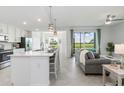 Bright open-concept living space with kitchen and golf course views at 12550 Galapagos Ct # 104, Venice, FL 34293