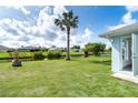 Backyard view of property on the water with mature palm tree and tropical landscaping at 15 Bunker Pl, Rotonda West, FL 33947
