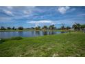 Scenic backyard featuring lush green grass and a serene view of a tranquil lake at 15 Oakland Hills Pl, Rotonda West, FL 33947