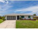 Charming single-story home featuring a well-maintained lawn and an attached garage at 15 Oakland Hills Pl, Rotonda West, FL 33947