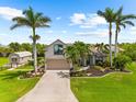 Stunning home with lush landscaping, a well manicured lawn and mature palm trees at 15521 Lakeland Cir, Port Charlotte, FL 33981