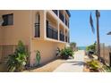 Oceanside condominium exterior with landscaped walkway and peek of beach at 1760 Gulf Blvd # 511, Englewood, FL 34223