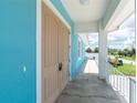 The covered entryway includes a secure double door, a full-length porch, and a neutral color palette with modern lighting at 1930 Massachusetts Ave, Englewood, FL 34224