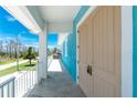 Entryway featuring a covered porch, double front doors, modern lighting, and views of the surrounding neighborhood at 1930 Massachusetts Ave, Englewood, FL 34224