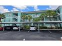 Inviting condo complex with covered parking, lush landscaping, and coastal design creates instant curb appeal at 19375 Water Oak Dr # 203, Port Charlotte, FL 33948