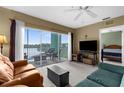 Comfortable living room with plush seating, neutral carpet, and access to a balcony overlooking the serene water view at 19375 Water Oak Dr # 203, Port Charlotte, FL 33948