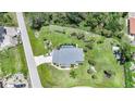 An aerial view showcasing a pool and an expansive lawn surrounded by lush trees at 196 Lecturn St, Port Charlotte, FL 33954