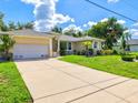 Welcoming home featuring an attached two-car garage and expansive driveway in a desirable neighborhood at 23 Pine Valley Ct, Rotonda West, FL 33947