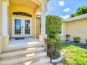 Inviting front entrance with double doors, decorative columns, and steps leading to a covered entryway at 23 Pine Valley Ct, Rotonda West, FL 33947