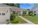 Well-manicured front yard featuring lush landscaping and a charming walkway leading to the entrance at 237 Park Forest Blvd, Englewood, FL 34223