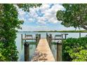 Picturesque wooden dock with seating, offering stunning water views surrounded by lush greenery at 2373 N Beach Rd # 1C, Englewood, FL 34223