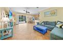 Open living space features tile flooring, slider doors, and access to the dining area and pool at 2588 Westberry Ter, North Port, FL 34286