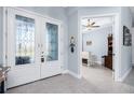 Bright foyer with tile flooring, glass double doors, and an open view into a living area with tray ceilings at 262 Rotonda N Blvd, Rotonda West, FL 33947