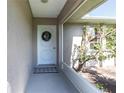 Cozy covered entry featuring a classic white front door adorned with a festive wreath and neutral accents at 3085 Crowder St, Punta Gorda, FL 33980