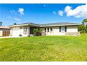 Inviting single-Gathering home with a lush green lawn and well-maintained landscaping under a clear blue sky at 3085 Crowder St, Punta Gorda, FL 33980