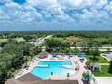 An aerial shot of the large community pool with ample seating and lush tropical landscaping at 3207 Village Ln, Port Charlotte, FL 33953