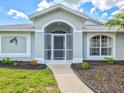 Inviting front entrance with a screened-in porch and decorative landscaping, creating a welcoming first impression at 34 Broadmoor Ln, Rotonda West, FL 33947