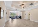 Spacious living room with tile flooring, tray ceilings, recessed lighting and a backyard view at 576 Box Elder Ct, Englewood, FL 34223