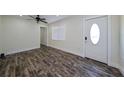 Bright living room featuring modern flooring, a ceiling fan, and a door with decorative glass at 700 Floral Ln, Port Charlotte, FL 33952