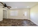 Bright living room with modern flooring, a ceiling fan, and a front door with decorative glass at 700 Floral Ln, Port Charlotte, FL 33952