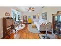 Bright living room showcasing hardwood floors, natural light, and comfortable furnishings at 7690 Castleberry Ter, Englewood, FL 34224