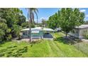 Charming single-story home with a well-maintained lawn, carport, and lush landscaping at 8224 Pinetree Ln, Englewood, FL 34224