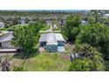 Overhead view of a cozy single-story home with shade trees and carport at 8224 Pinetree Ln, Englewood, FL 34224