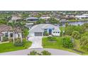 Aerial view of a lovely single-Gathering home situated on waterfront property with lush landscaping at 10079 Lebanon Dr, Port Charlotte, FL 33981