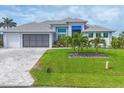 Well-maintained home with a manicured lawn, tasteful landscaping, and a driveway made with pavers at 10079 Lebanon Dr, Port Charlotte, FL 33981