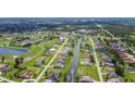 Expansive aerial view of a residential community featuring lush green lawns and waterfront properties along a canal at 104 Mark Twain Ln, Rotonda West, FL 33947
