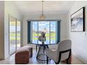 Cozy dining area with a glass-top table, stylish chairs, and a large window overlooking the water at 104 Mark Twain Ln, Rotonda West, FL 33947
