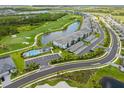 Aerial view of condo community featuring pool, golf course, pond, and winding roads at 12470 Wellen Golf St # 107, Venice, FL 34293