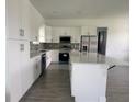 Bright kitchen featuring white cabinetry, stainless steel appliances, an island with quartz countertops, and patterned backsplash at 14149 Whittier Ln, Port Charlotte, FL 33981