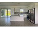 Bright kitchen featuring white cabinetry, stainless steel appliances, an island with quartz countertops, and patterned backsplash at 14149 Whittier Ln, Port Charlotte, FL 33981