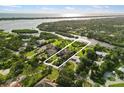 Aerial view of waterfront property showcasing lush landscape and the home's layout at 1415 Bayshore Dr, Englewood, FL 34223