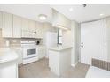 Efficient kitchen with white cabinetry, appliances, and a cozy breakfast bar at 1701 Beach Rd # 207, Englewood, FL 34223