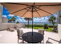 Outdoor patio area with seating, umbrella, and stunning waterfront views for relaxation at 1701 Beach Rd # 207, Englewood, FL 34223