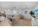 Bright living room featuring neutral colors, comfortable seating, and stylish decor with wood flooring at 1730 Bluebird Ln, Englewood, FL 34224