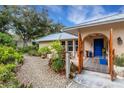 Inviting entrance featuring a vibrant blue door and a meticulously landscaped walkway at 1733 Belvidere Rd, Englewood, FL 34223