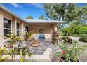 Charming porch with stone flooring, water feature, blue bench, and potted plants at 1733 Belvidere Rd, Englewood, FL 34223